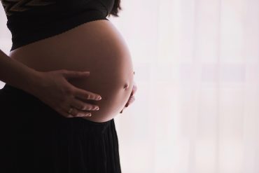 Das Foto zeigt den Bauch einer schwangeren Frau.