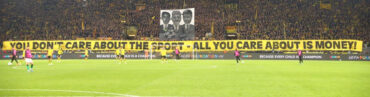 BVB-Fans demonstrieren gegen die zunehmende Kommerzialisierung im Fußball. Auf einem Spruchbanner steht: "You don't care about the sport - All you care about is money."