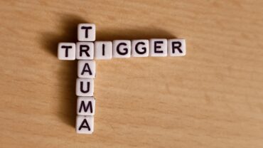 Das Bild zeigt die Worte Trigger und Trauma, gelegt aus Buchstabenblöcken.