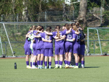 Spielerinnen der U17 der SGS Essen stehen vor einem Fußballspiel in der Regionalliga West in einem Spielerkreis.