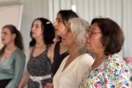 Frauen des Migrantinnen-Chors stehen nebeneinander und singen.