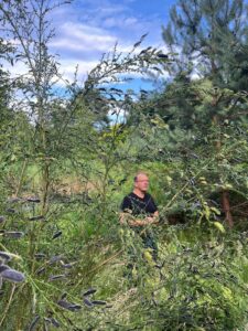 Patrick Knopf bei der Führung. Er steht im Moor des Rombergparks und erklärt den Teilnehmenden, wie ein Moor funktioniert.