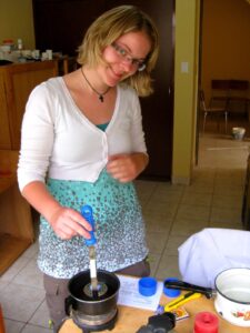 Die junge Johana steht im Labor ihres Projektes in Peru und lächelt in die Kamera. Sie baut gerade ein Teil für ein Hörgerät