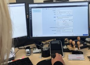Blick über die Schulter auf einen Desktop-Bildschirm. Auf dem Bildschirm ist die Benutzeroberfläche von Doctolib zu sehen. Auf dieser können manuell Termine bei Doctolib angelegt werden.